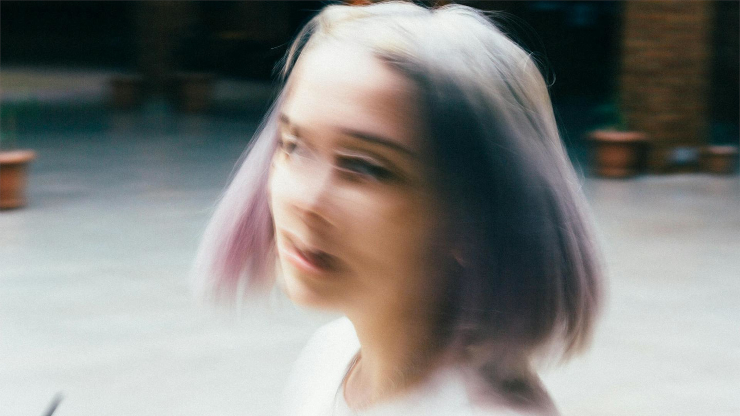 Verschwommenes Porträt einer nachdenklichen Frau draußen – symbolisiert innere Zerrissenheit, Unsicherheit und das Loslassen in einer offenen Beziehung